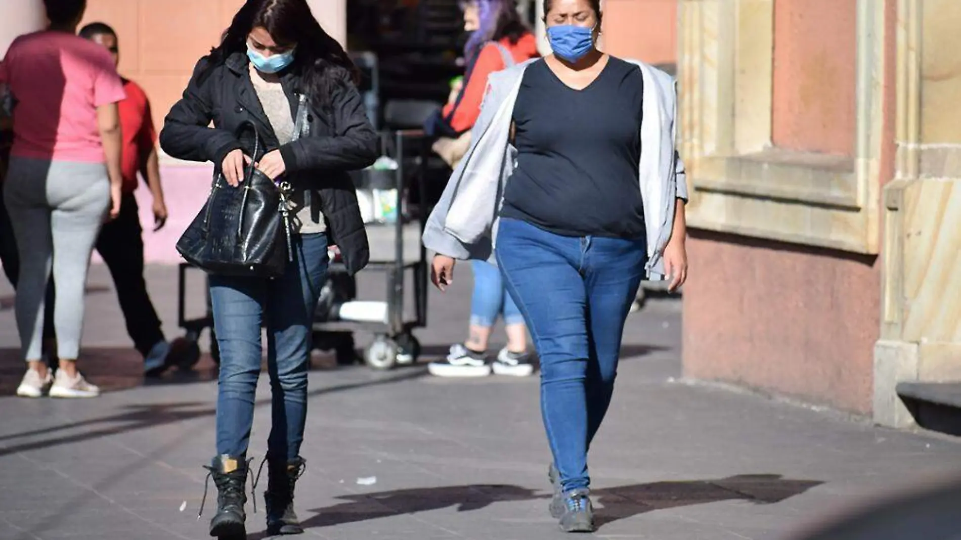 Mujeres con cubrebocas caminando